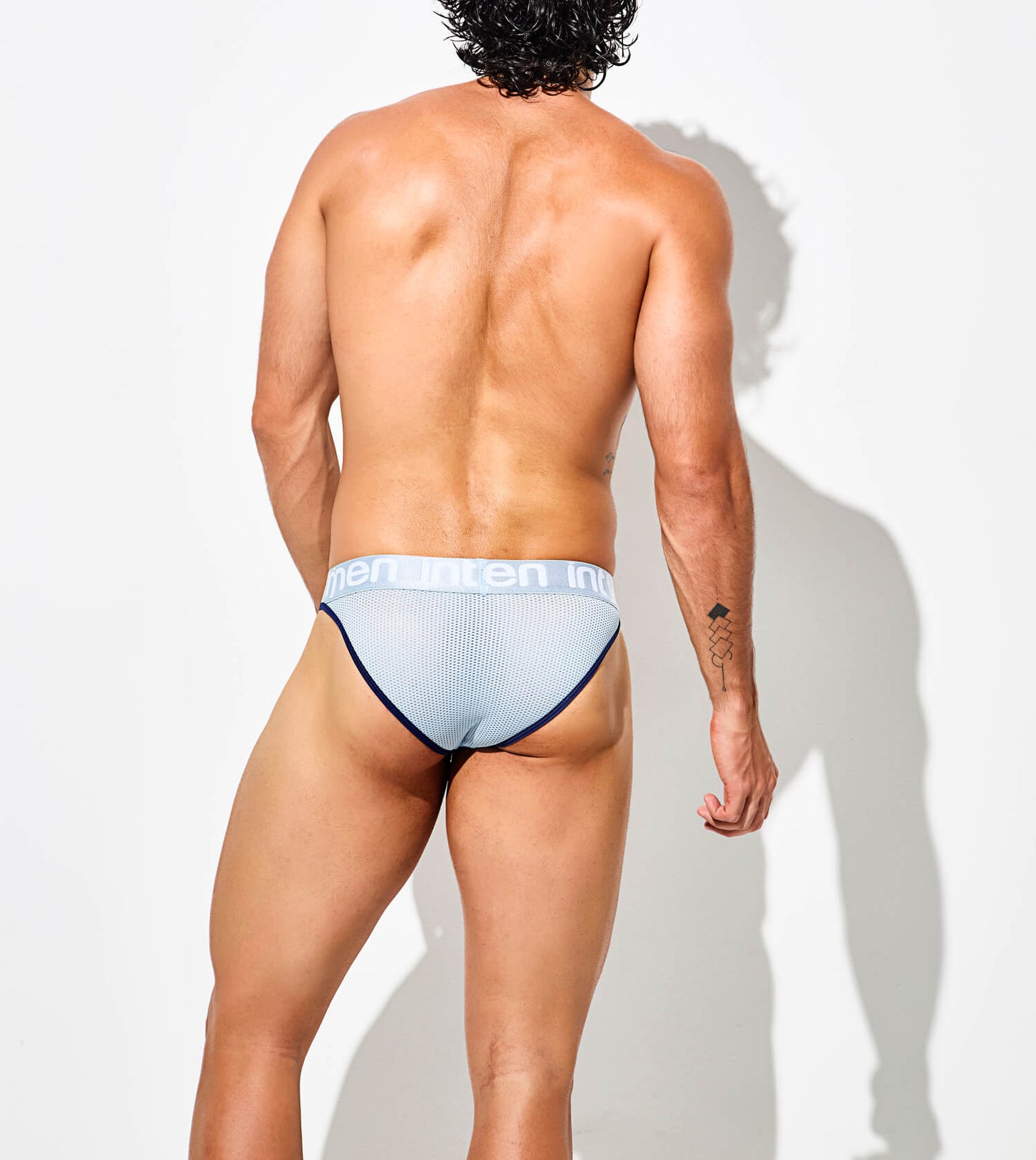 Back view – light mesh thong with wide Intymen logo waistband and navy blue trim.