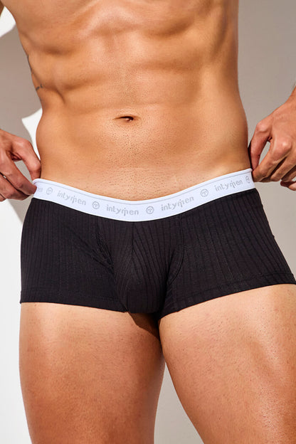 Close-up of black boxer briefs with a white waistband.